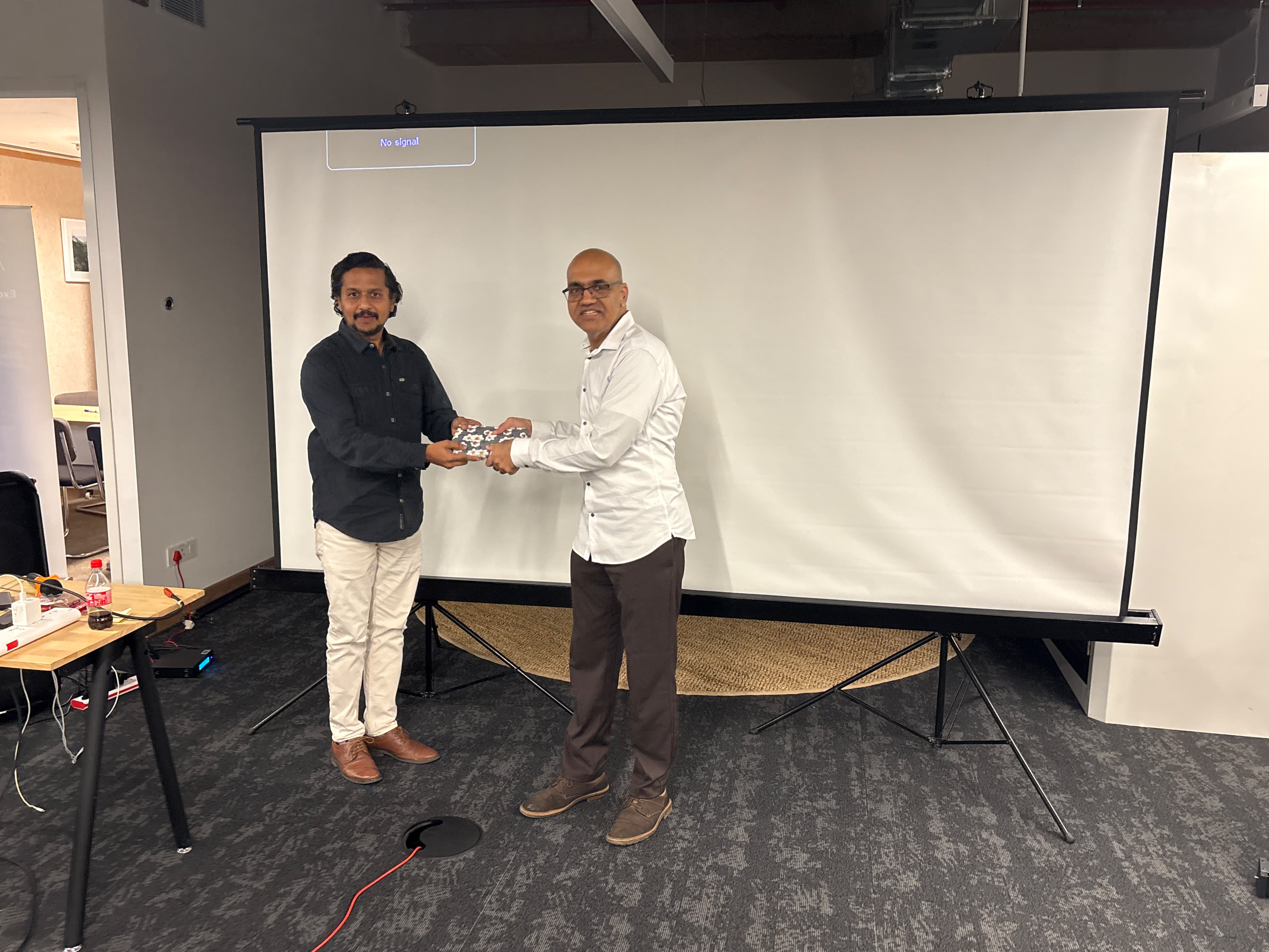 Speakers exchanging a token of appreciation at the event