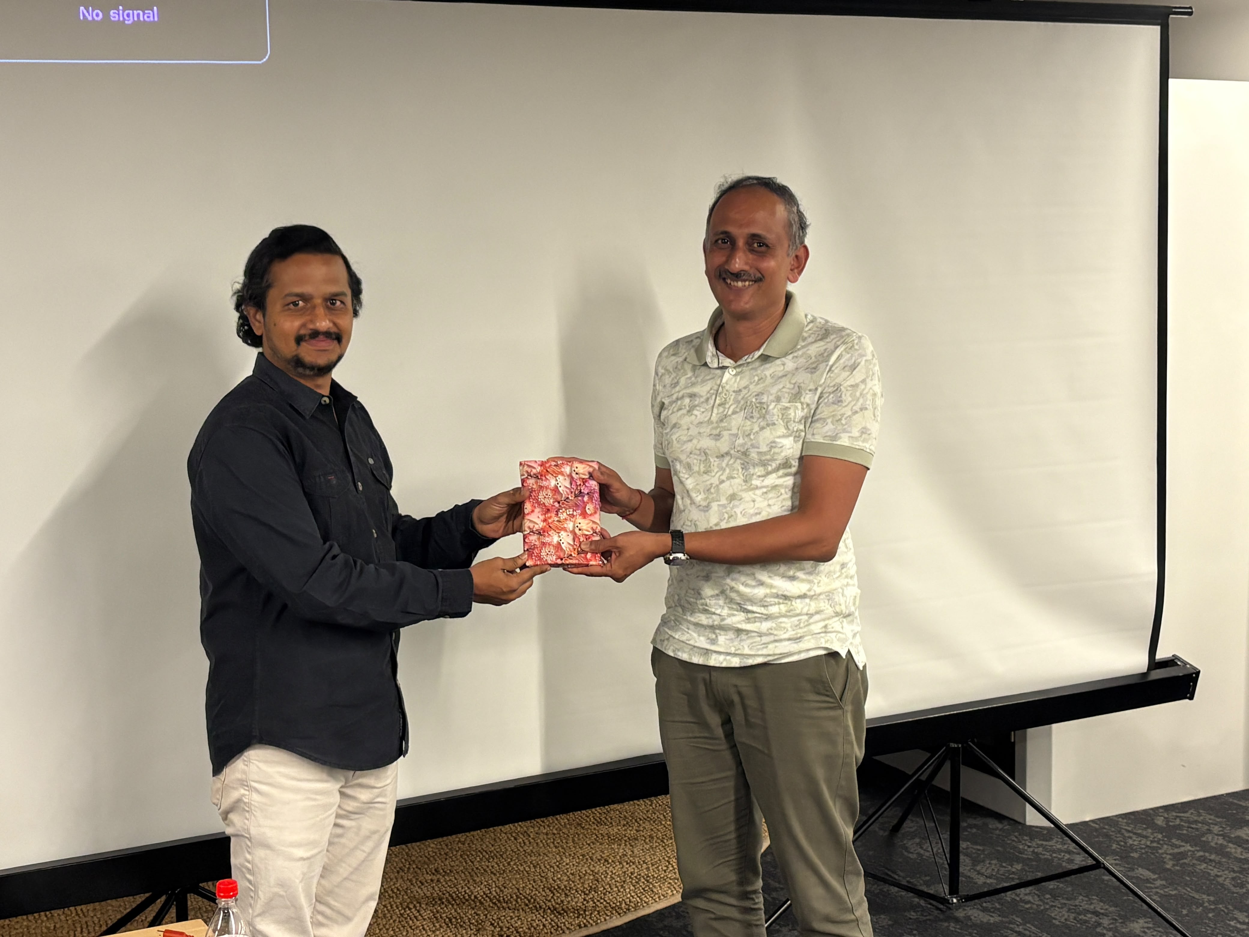 Speakers exchanging gifts at the Anthropic CCCL AI Security event