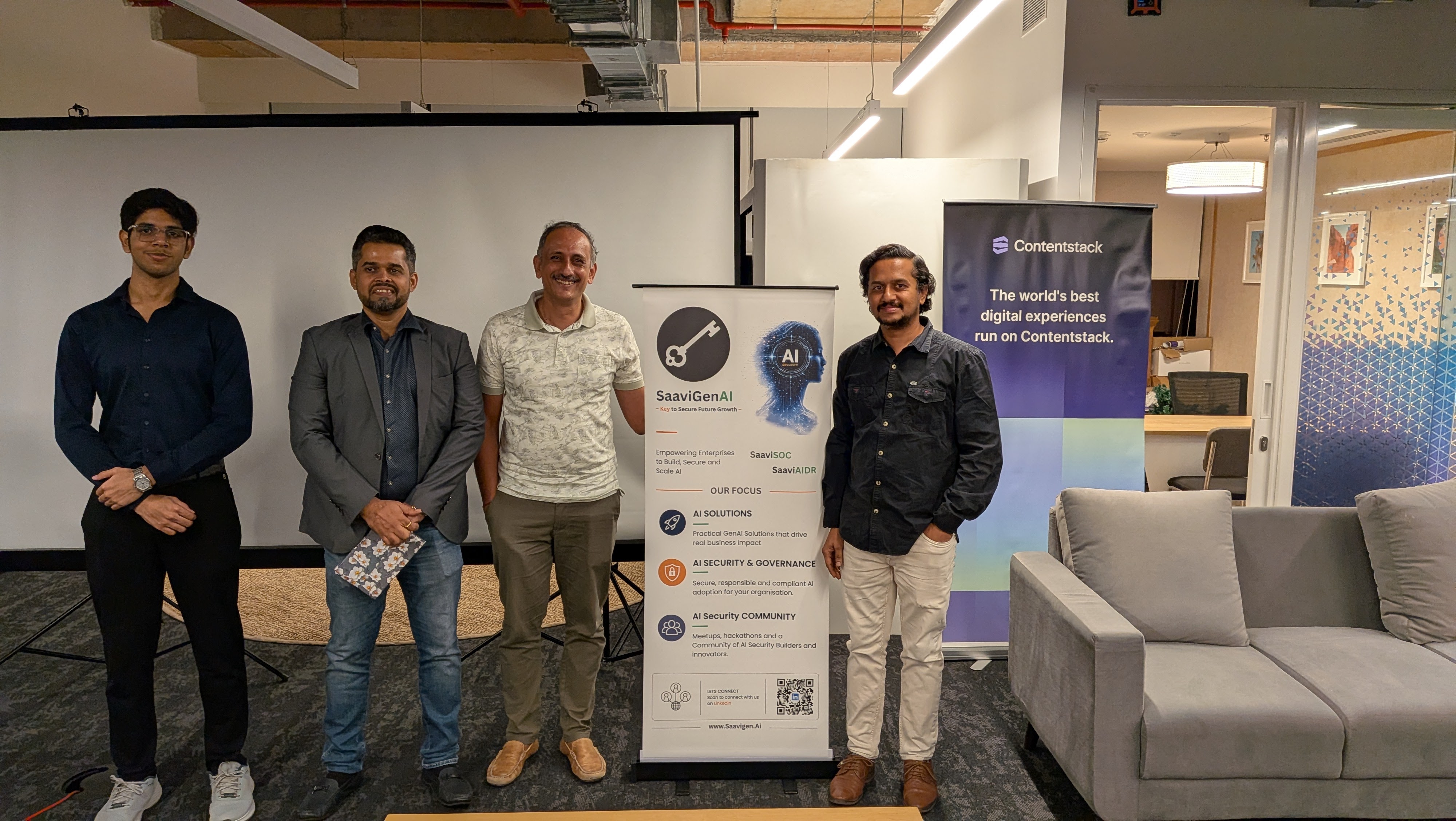 Attendees posing with the SaaviGenAI and Contentstack banners at the event