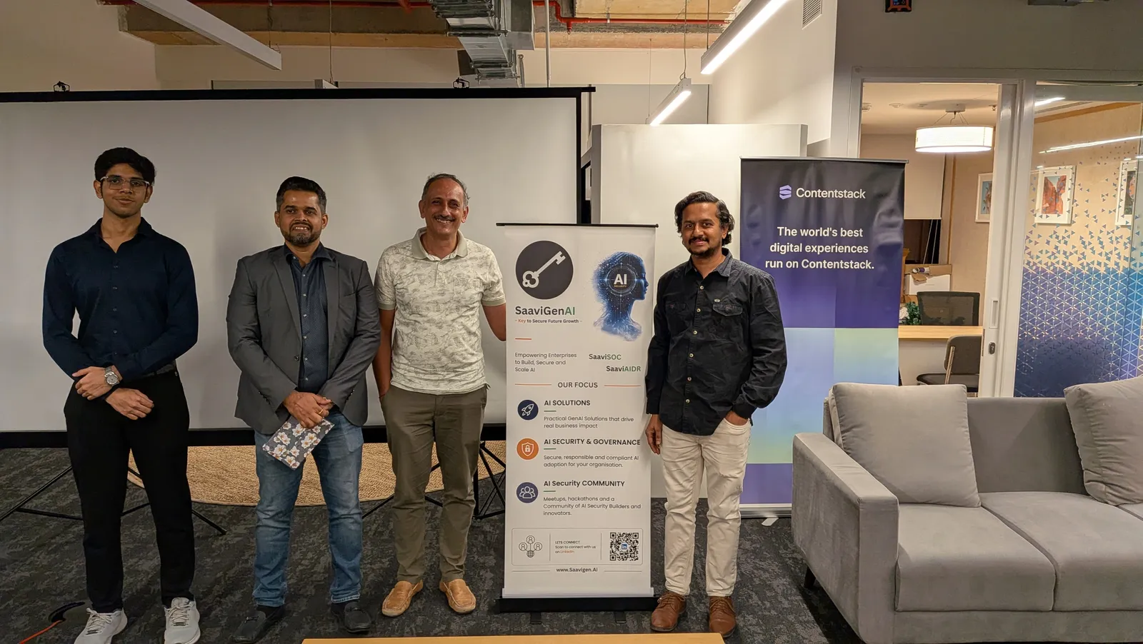 Attendees posing with the SaaviGenAI and Contentstack banners at the event